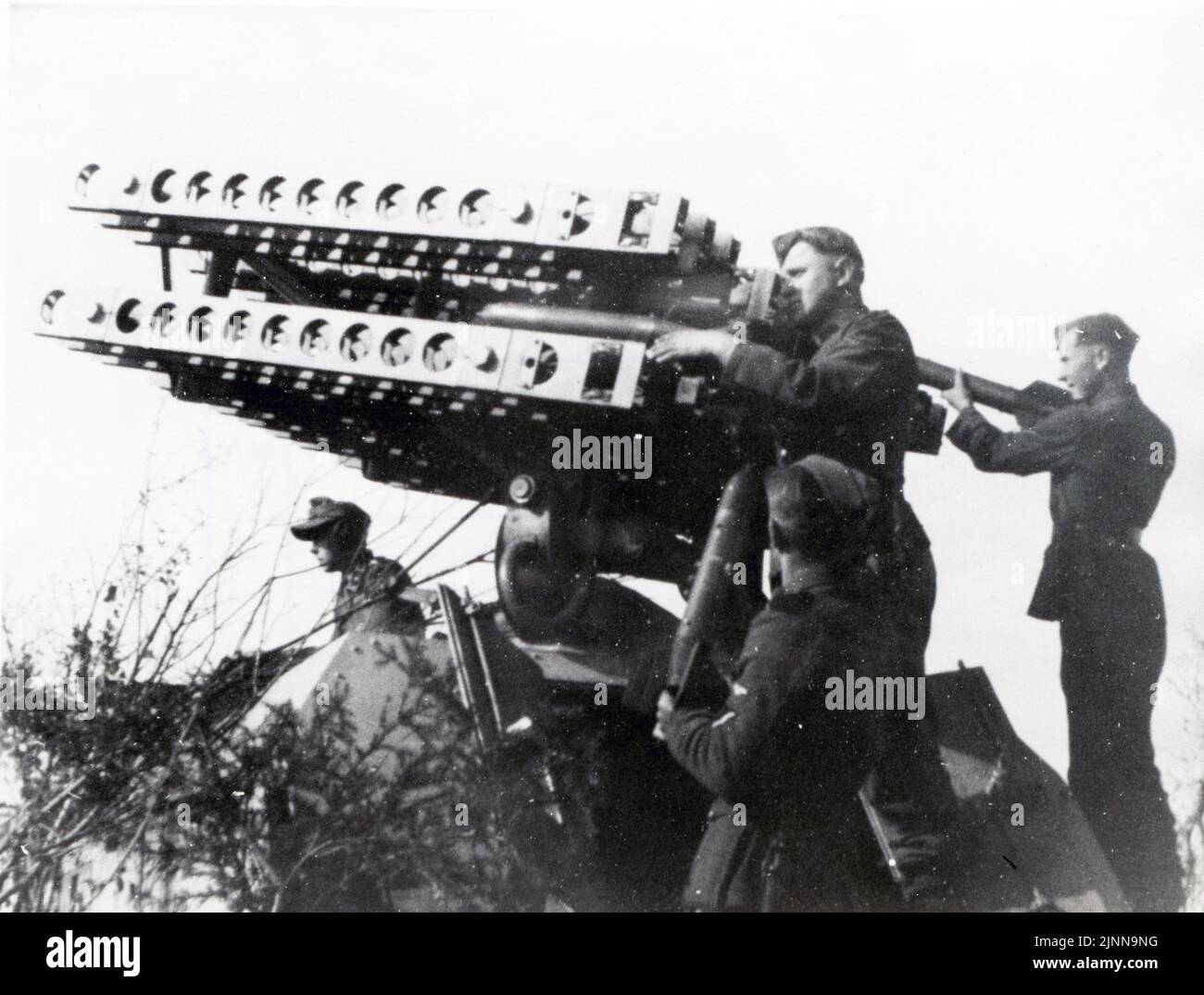 Foto en B&W de la Segunda Guerra Mundial Soldados alemanes cargan cohetes en un Lanzador Katyusha Caprured montado en un portaaviones blindado Maultier. Foto de stock