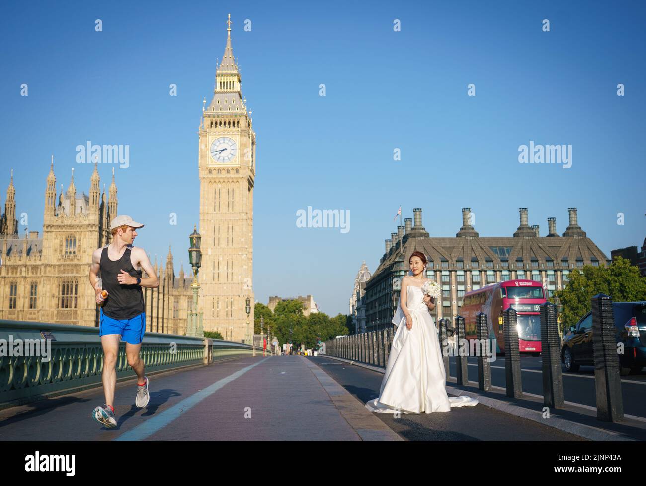 Una novia posa para los retratos de boda a primera hora de la mañana en el Puente de Westminster, Londres, ya que se ha declarado una sequía en algunas partes de Inglaterra tras el verano más seco de los últimos 50 años. Fecha de la foto: Sábado 13 de agosto de 2022. Foto de stock