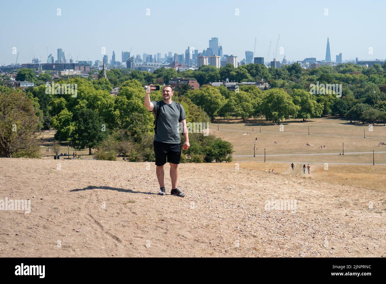 Un hombre toma un selfie de la cima de Primrose Hill, al norte de Londres, como una sequía ha sido declarada en partes de Inglaterra después del verano más seco de 50 años. Fecha de la foto: Sábado 13 de agosto de 2022. Foto de stock