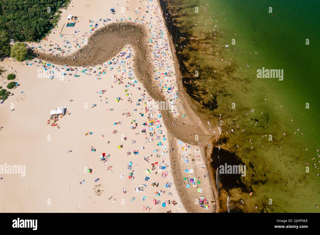 La costa del Báltico, gente que se bañan en el mar y en la desembocadura del río Oliwski al mar durante el caluroso fin de semana de verano Foto de stock