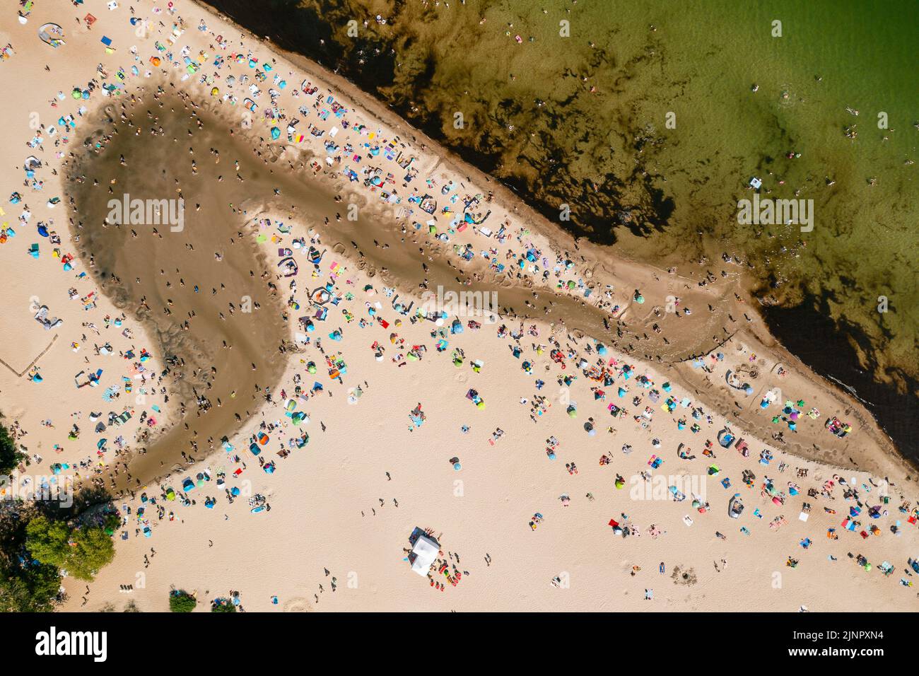 La costa del Báltico, gente bañándose en el mar y en la desembocadura del río Oliwski al mar durante el caluroso fin de semana de verano, directamente por encima de la perspectiva Foto de stock