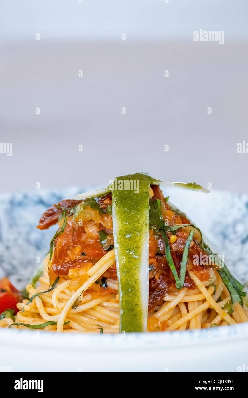Espaguetis con salsa picante, pimiento y queso parmesano rallado Foto de stock