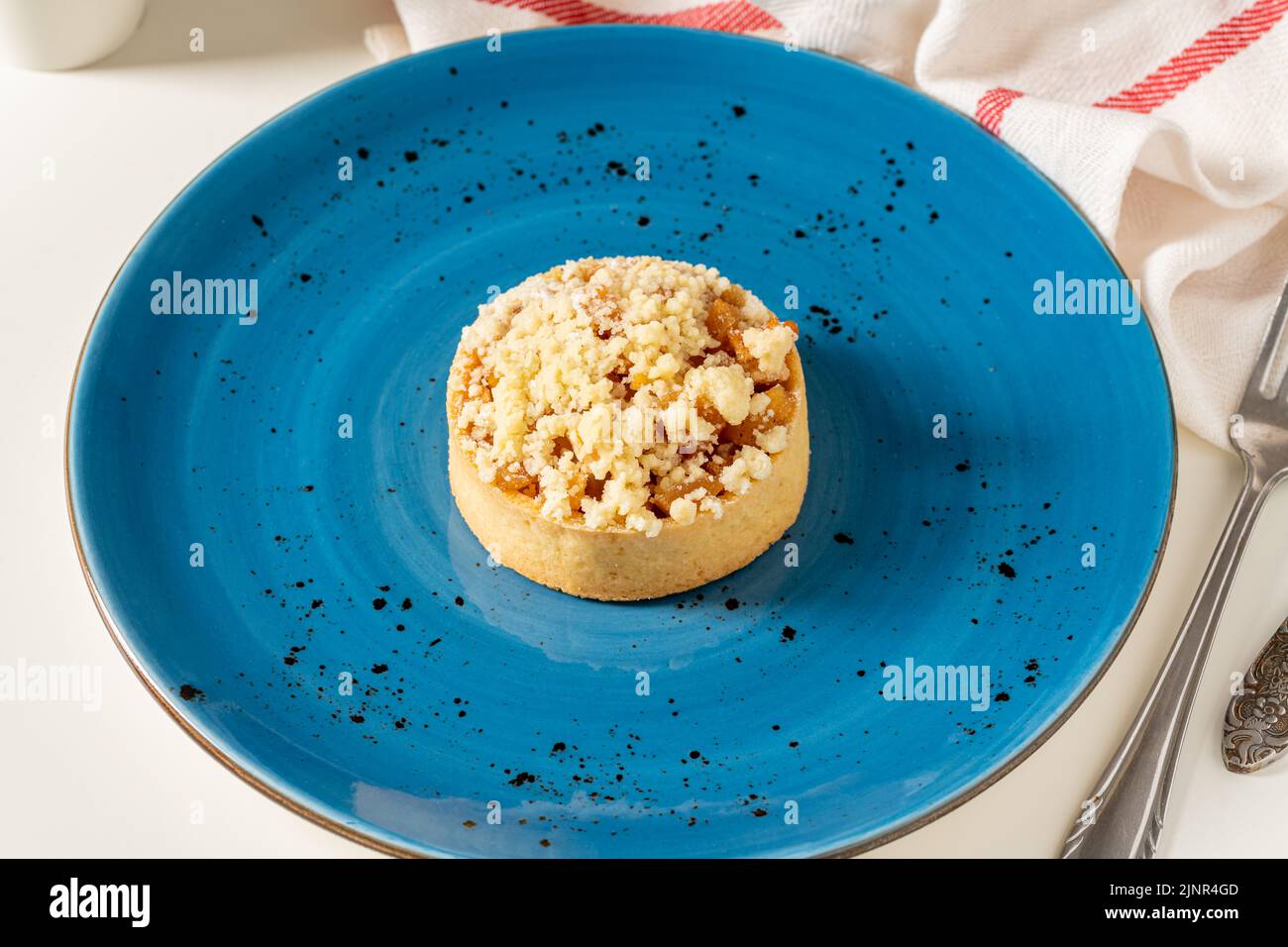 Pastel de manzana recién horneado en una porción en un plato de porcelana azul Foto de stock