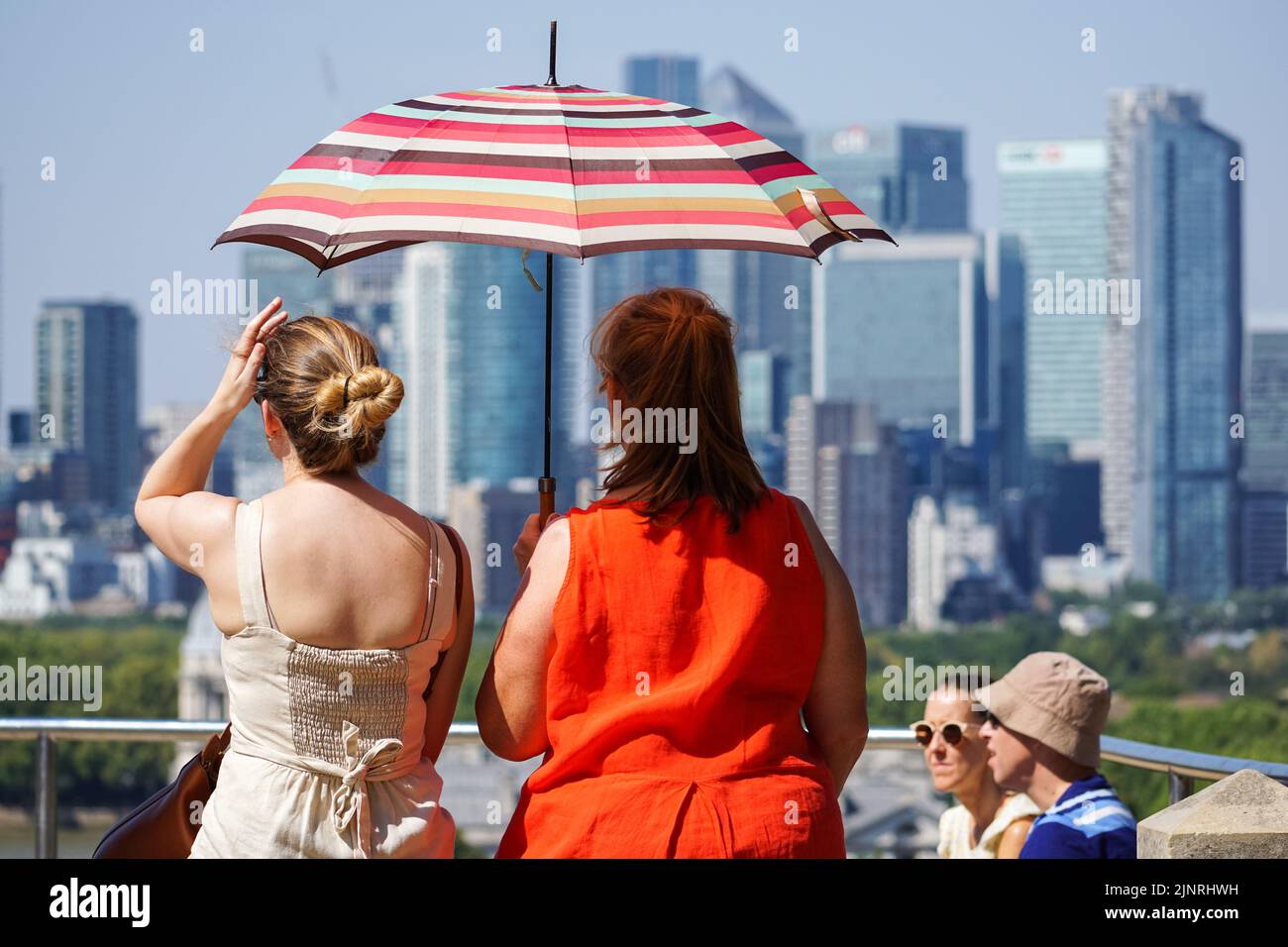 Londres, Reino Unido. 13th de Ago de 2022. Clima en Reino Unido: Visitantes con sombrilla escondida del sol en Greenwich Park durante la ola de calor. Crédito: Marcin Rogozinski/Alamy Live News Foto de stock