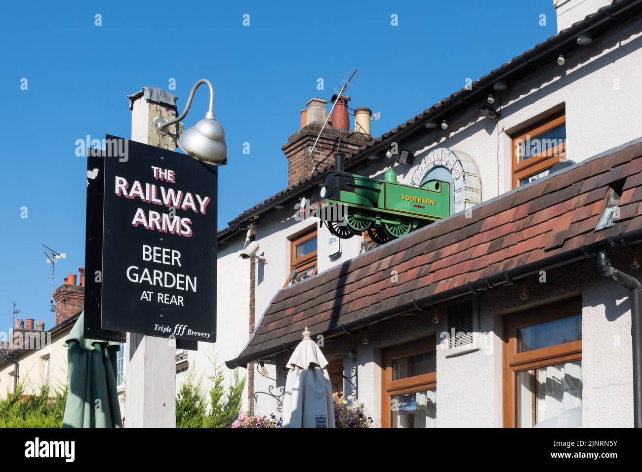 El pub Railway Arms con un tren modelo en la pared, Alton, Hampshire, Inglaterra, Reino Unido Foto de stock