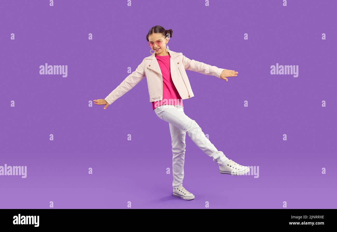 Retrato de niño feliz con un conjunto elegante y casual sobre fondo de estudio púrpura Foto de stock