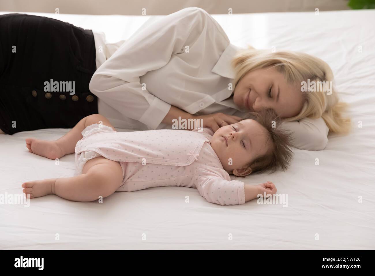 Vista de cerca tranquila bebé y papá durmiendo en la cama Foto de stock