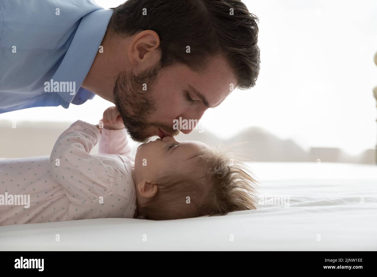 Primer plano ver joven padre amoroso besando linda hija infantil Foto de stock