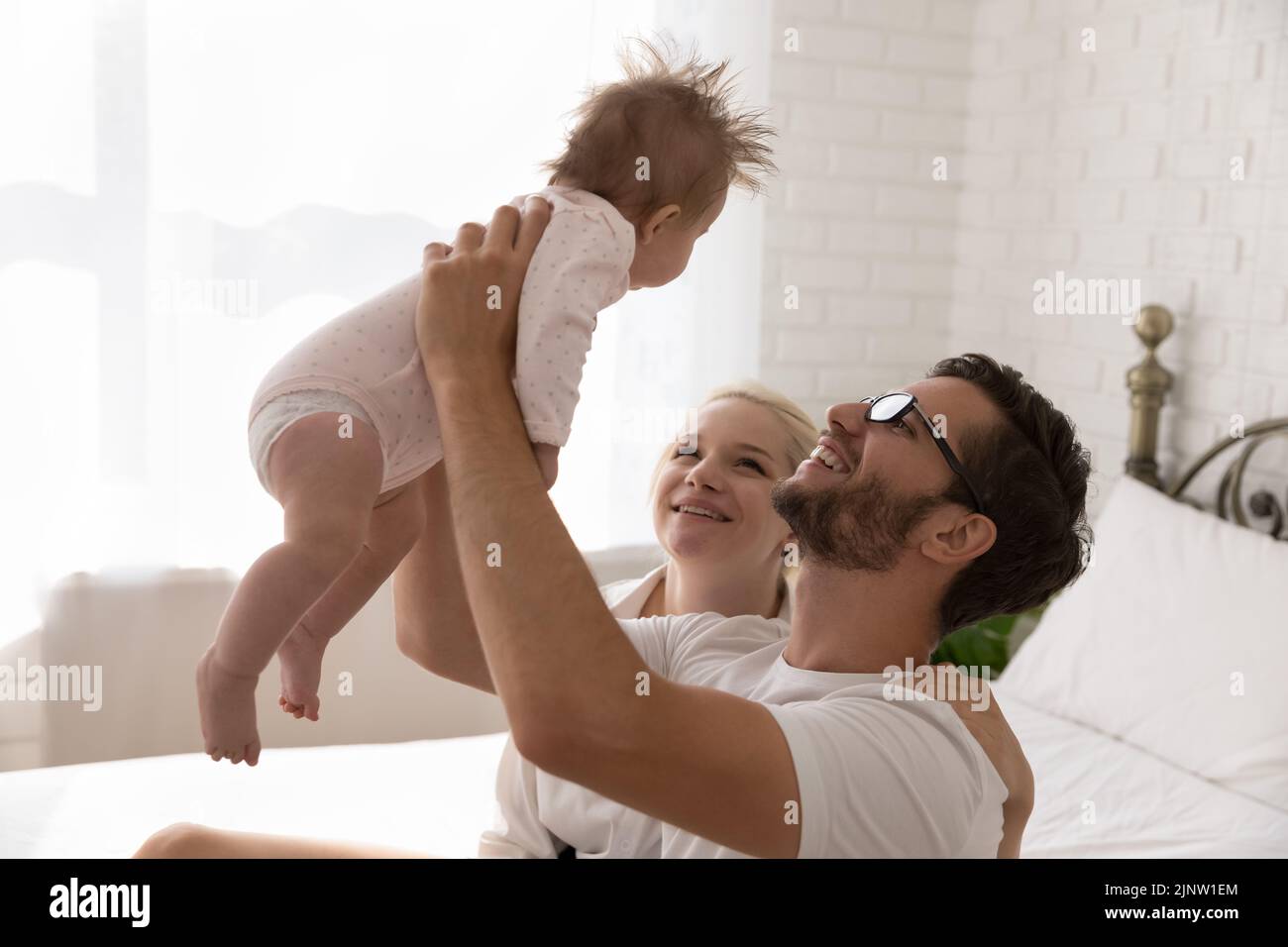 Los padres jóvenes pasan tiempo con el lindo bebé recién nacido Foto de stock