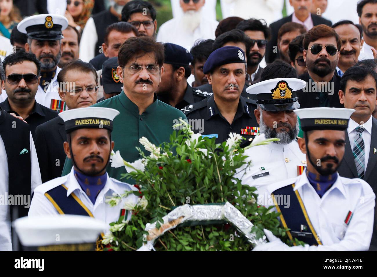 El Ministro Principal de Sindh Syed Murad Ali Shah camina con oficiales navales para poner una corona durante una ceremonia para celebrar el Día de la Independencia de Pakistán 75th, en el Mausoleo de Muhammad Ali Jinnah en Karachi, Pakistán 14 de agosto de 2022. REUTERS/Akhtar Soomro Foto de stock