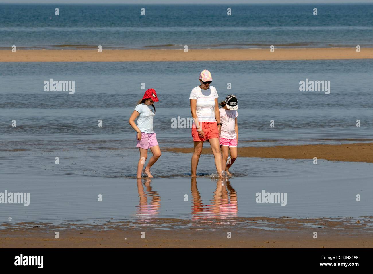 Southport, Merseyside, 14 de agosto de 2022. La gente se dirige hacia las doradas arenas de la playa Southport Beach para refrescarse y divertirse en las sofocantes olas que cubren el Reino Unido. Crédito: Cernan Elias/Alamy Live News Foto de stock