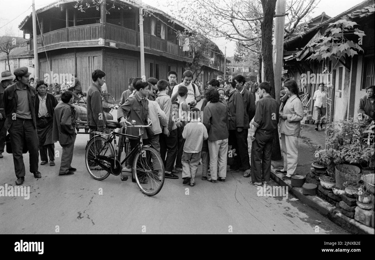 LA gente DE XIAN CHINA curiosamente se reúne alrededor de un fotógrafo en el trabajo Foto de stock