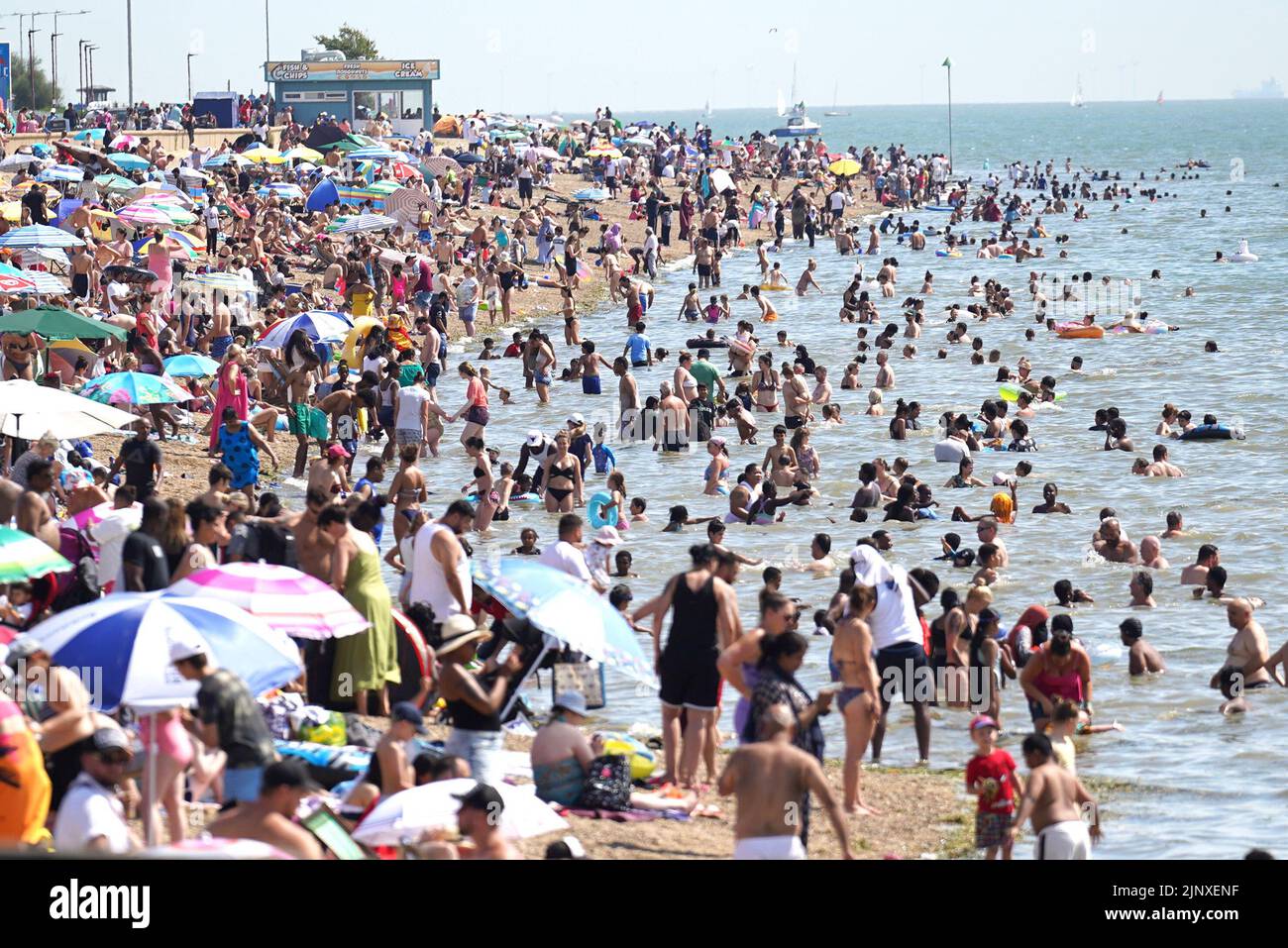 La gente se reúne en el clima caluroso de la playa Southend-on-Sea. Se ha declarado una sequía en algunas partes de Inglaterra después del verano más seco de 50 años. Fecha de la foto: Domingo 14 de agosto de 2022. Foto de stock