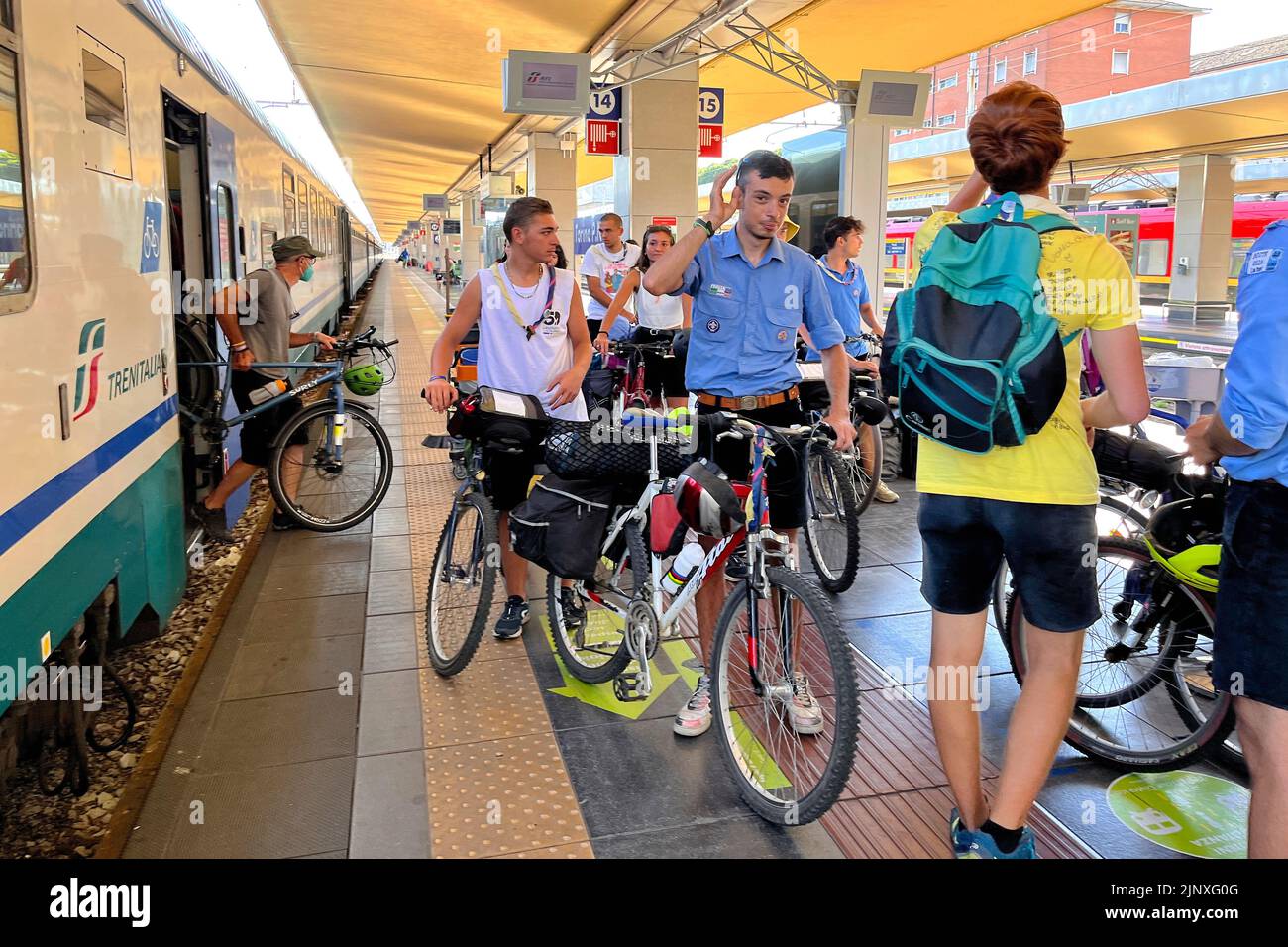 Los chicos exploradores salen del tren con sus bicicletas. Milán, Italia - Agosto 2022 Foto de stock