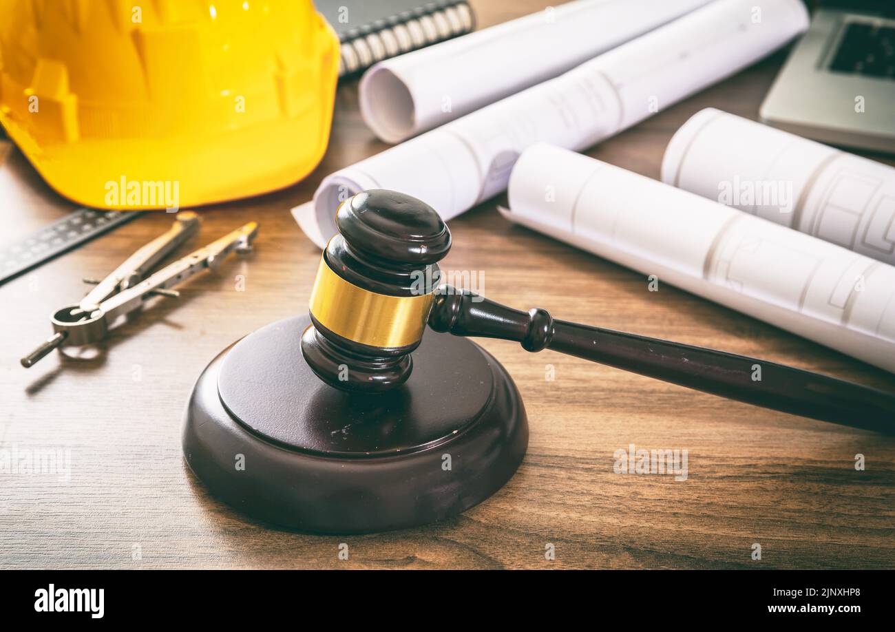 Construcción y Derecho laboral. Juzgue los dibujos del mazo y de la construcción en una mesa de madera, vista de cerca. Foto de stock