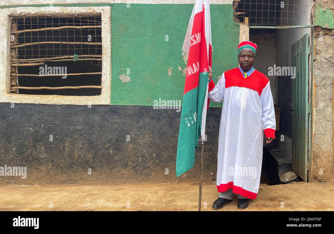 Pastor Josephat Muhando sostiene su bandera de la iglesia antes de las oraciones del domingo después de la elección general conducida por la Comisión Independiente Electoral y de Límites (IEBC) en la Iglesia Divina Africana en el pueblo de Silanga del distrito de Kibera en Nairobi, Kenia 14 de agosto de 2022. REUTERS/Thomas Mukoya Foto de stock