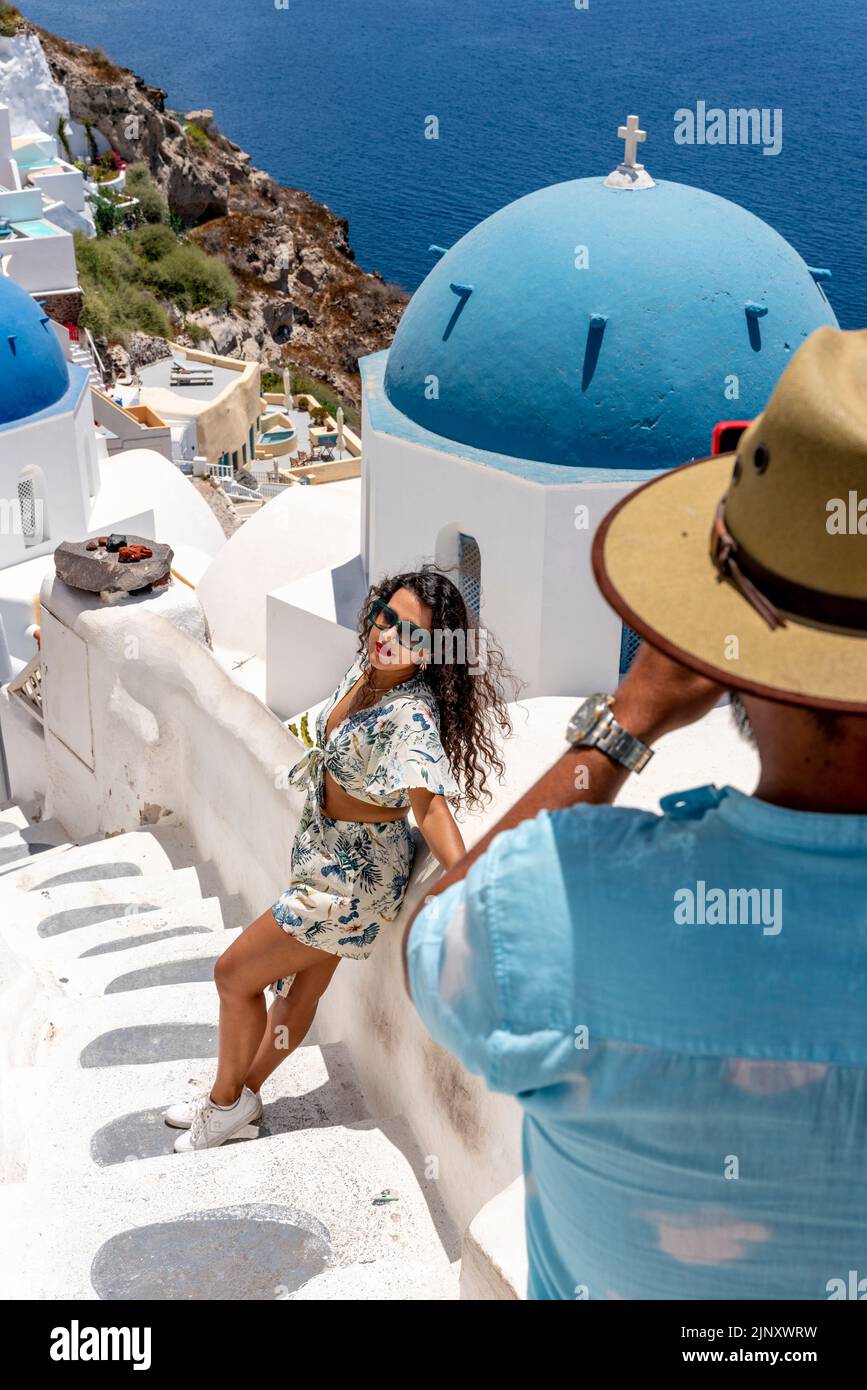 Jóvenes posando para Fotos en un Mirador Clásico en la Ciudad de Oia, Santorini, Islas Griegas, Grecia. Foto de stock