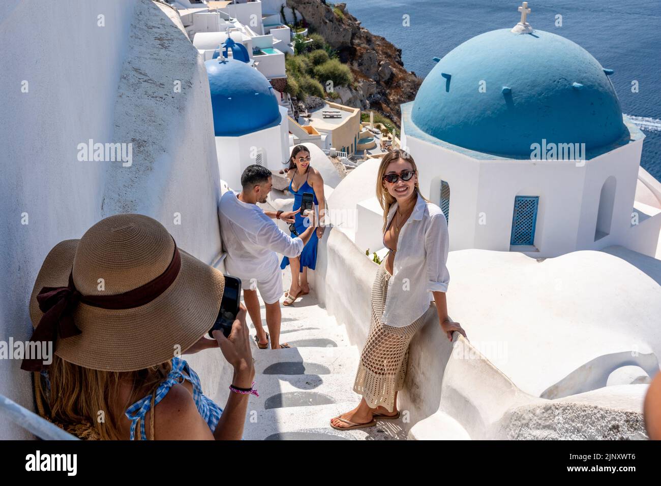 Jóvenes posando para Fotos en un Mirador Clásico en la Ciudad de Oia, Santorini, Islas Griegas, Grecia. Foto de stock