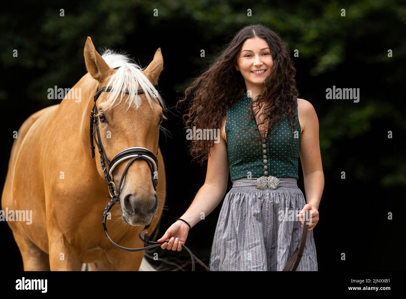 Retrato de una joven mujer acurrúquese con su caballo. Ecuestre y caballo escena del equipo Foto de stock