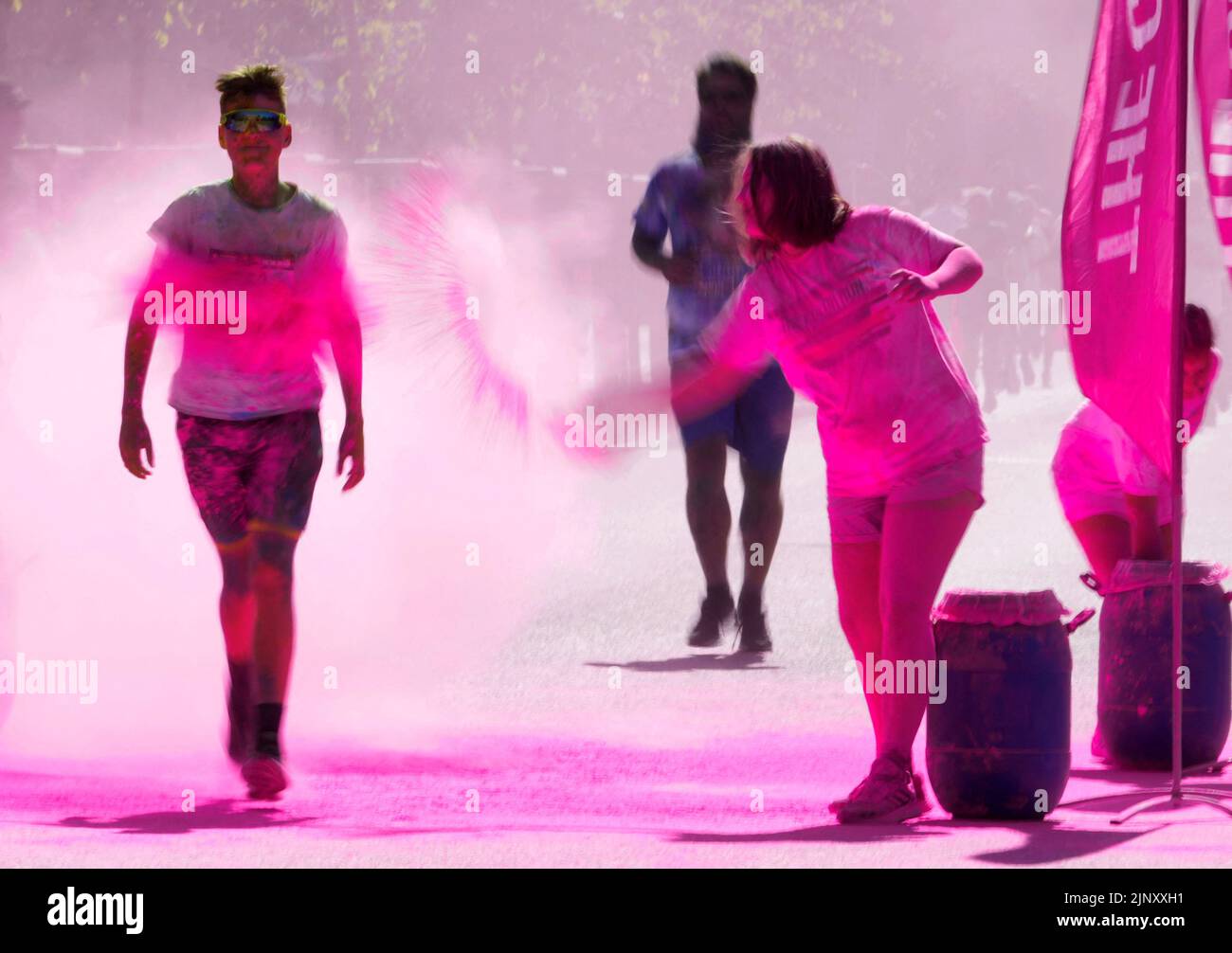 El polvo coloreado se vierte sobre un participante durante el evento Color Run en Jurmala, Letonia el 14 de agosto de 2022. REUTERS/Ints Kalnins Foto de stock