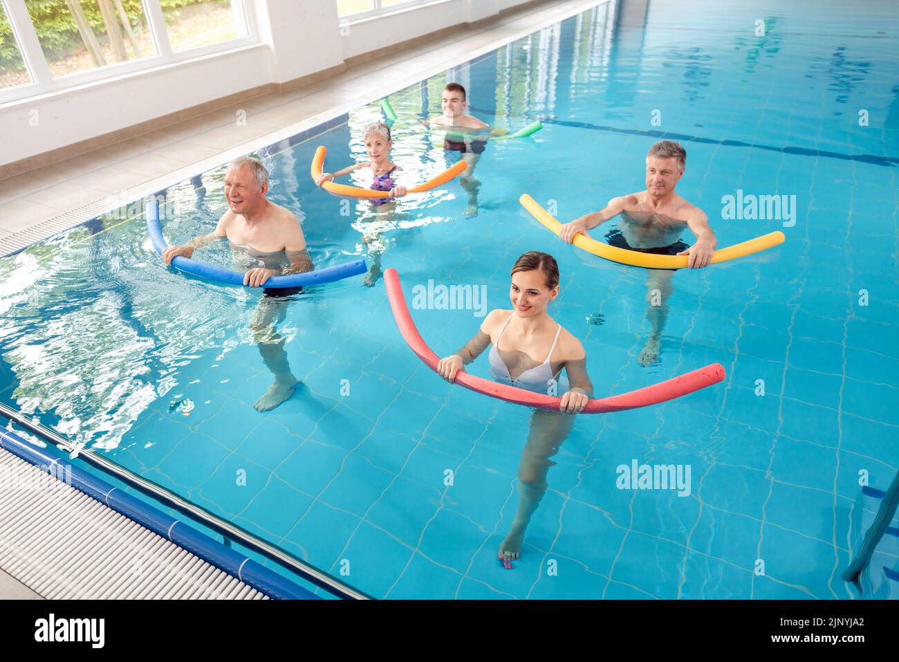 Las mujeres y los hombres en los ejercicios en el agua durante la removilización Foto de stock