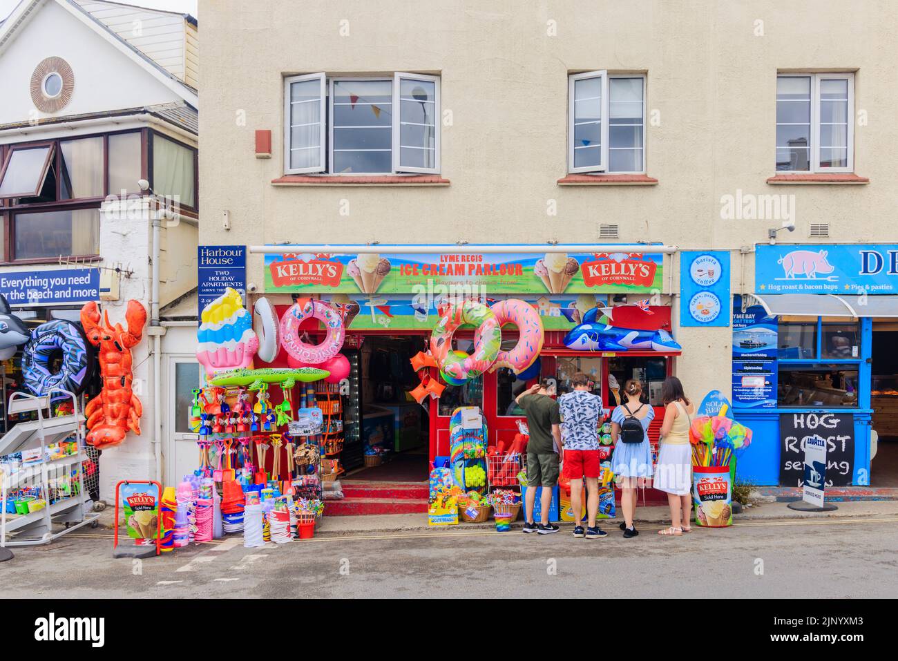 Heladería y exhibición al borde de la carretera de inflables y juguetes de playa en una tienda al lado del Cobb, Lyme Regis en la Costa Jurásica en Dorset, al sur de Inglaterra Foto de stock