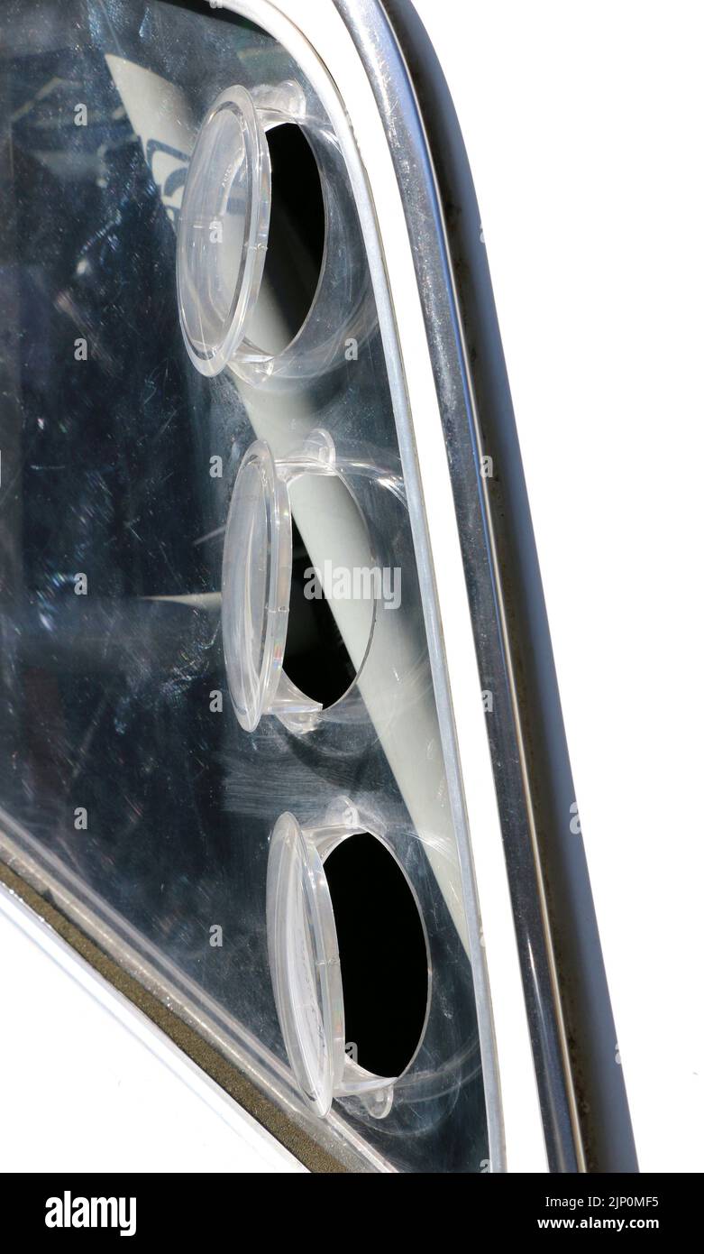 Tres ventanas de ventilación redondas en la ventana trasera del coche antiguo blanco y negro. Foto de stock