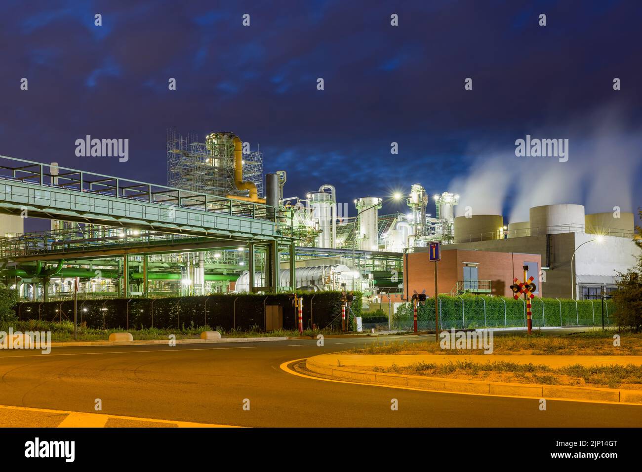 Vista nocturna de la industria pesada iluminada en el puerto de Amberes en Bélgica Foto de stock
