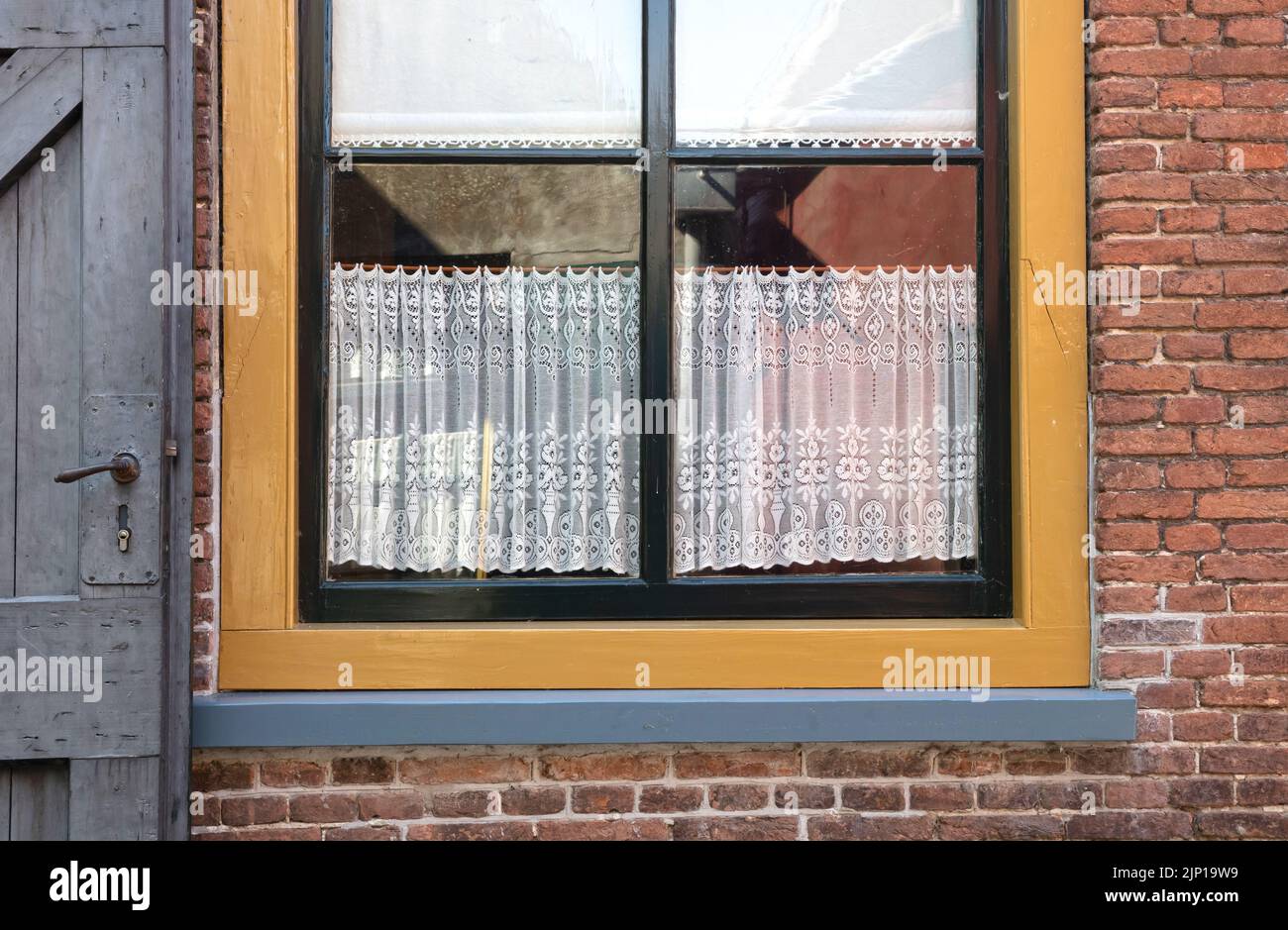 Ventana de acogedora casa con cortinas vintage, los Países Bajos del pasado Foto de stock