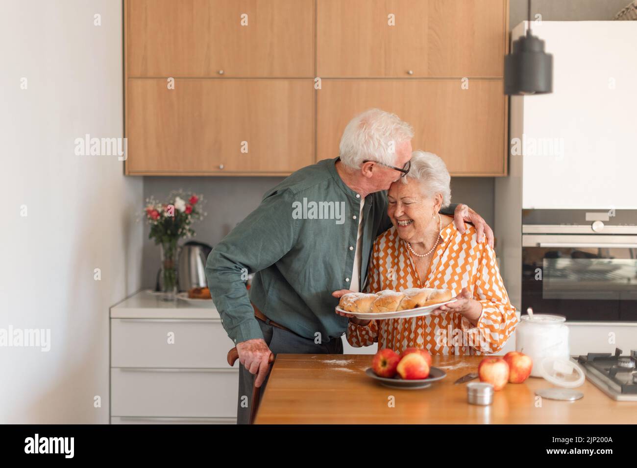 Feliz pareja mayor con pan trenzado dulce casero con pasas. Foto de stock