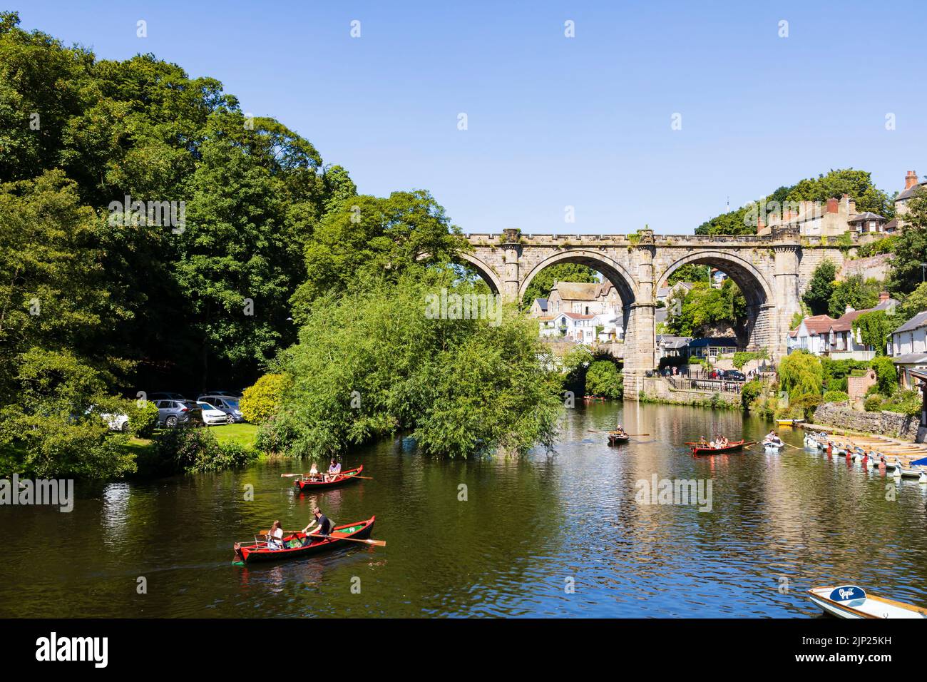 El viaducto del ferrocarril sobre el río Nidd, Knaresborough, North Yorkshire, Inglaterra. Día caluroso de verano con la gente en los barcos en el río. Foto de stock