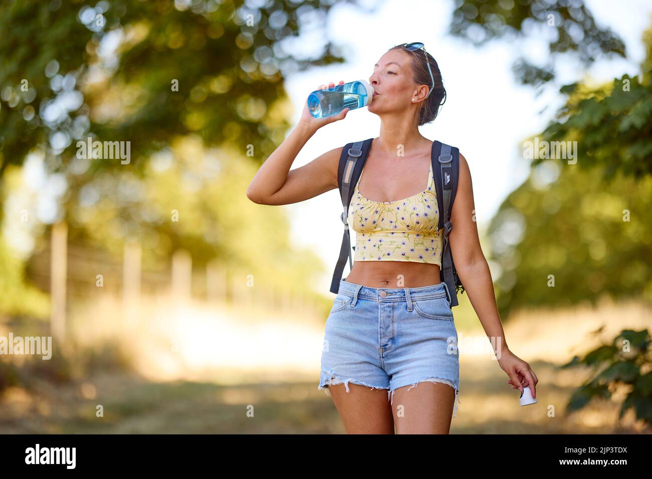 Mujer relajándose al aire libre con una botella de agua Foto de stock