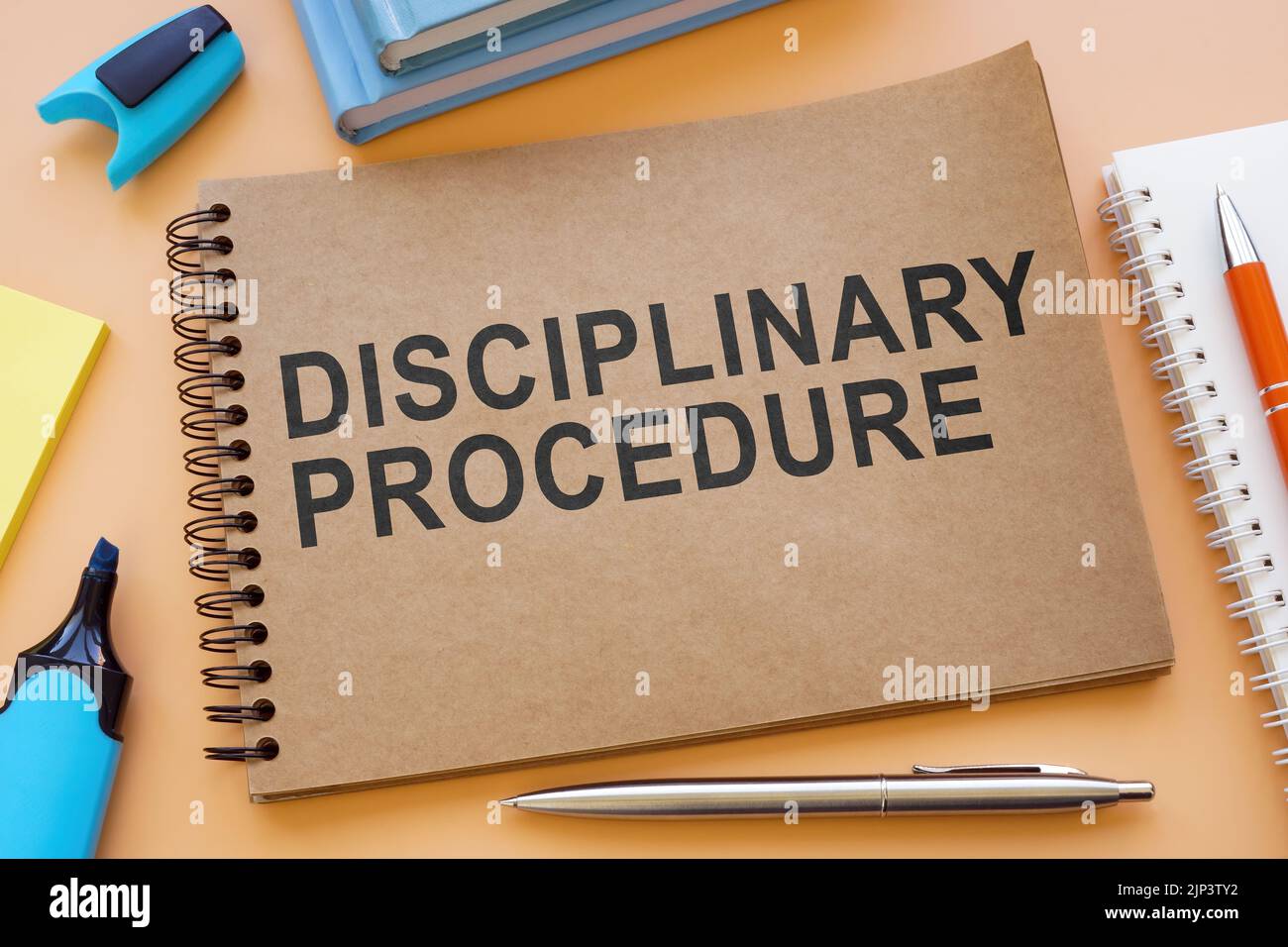Cuaderno sobre el procedimiento disciplinario con papeles sobre la mesa. Foto de stock