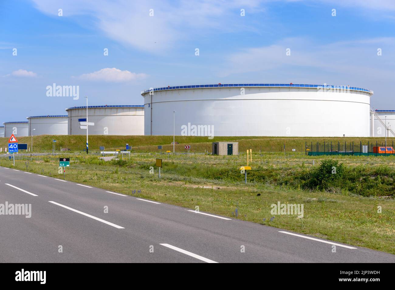 Grandes tanques de crudo en una terminal de petróleo en un soleado día de verano. Puerto de Rotterdam, Países Bajos. Foto de stock