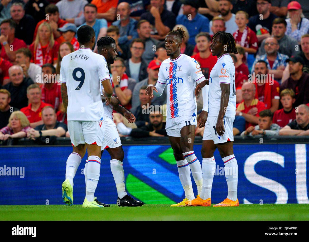 Wilfried Zaha (segunda derecha) de Crystal Palace celebra con sus compañeros de equipo después de marcar el primer gol de su equipo durante el partido de la Premier League en Anfield, Liverpool. Fecha de la foto: Lunes 15 de agosto de 2022. Foto de stock