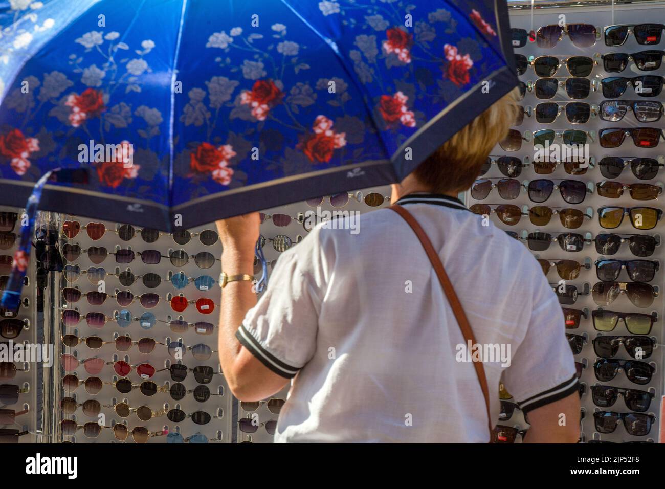 Moscú, Rusia. 15th de agosto de 2022. Una mujer elige gafas de sol en un mostrador de la calle Arbat, en el centro de Moscú, en un día sensual, en Rusia Foto de stock