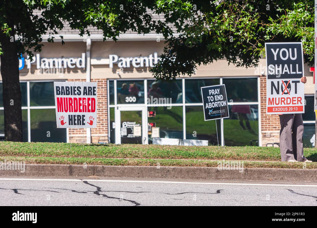 LAWRENCEVILLE, GA: Una persona tiene un cartel de pro vida fuera de una clínica de Planned Parenthood el 9 de octubre de 2021 en Lawrenceville, GA. Foto de stock