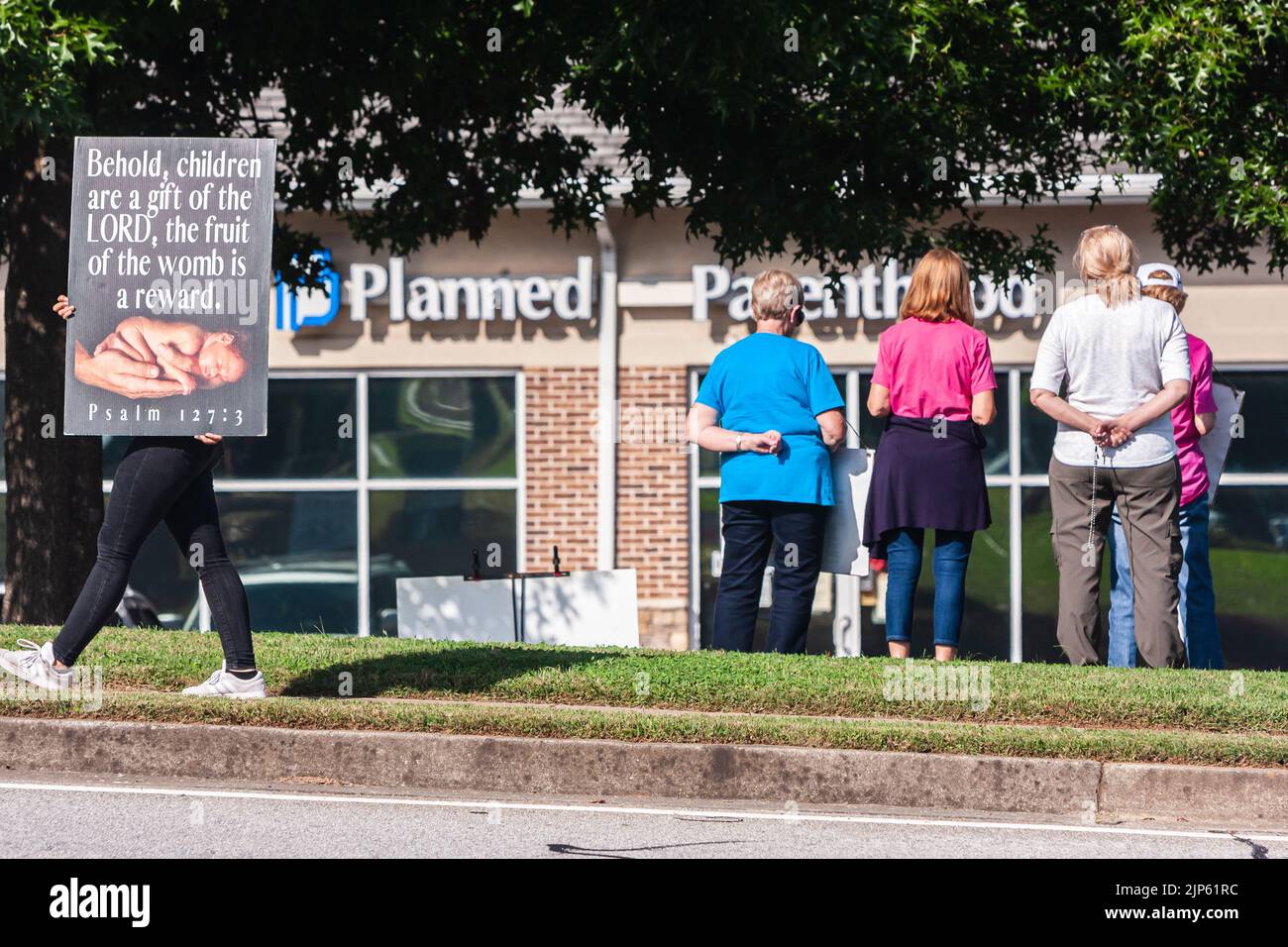 LAWRENCEVILLE, GA: Varias mujeres en contra del aborto se ponen de pie y brillan frente a una clínica de Planned Parenthood el 9 de octubre de 2021. Foto de stock