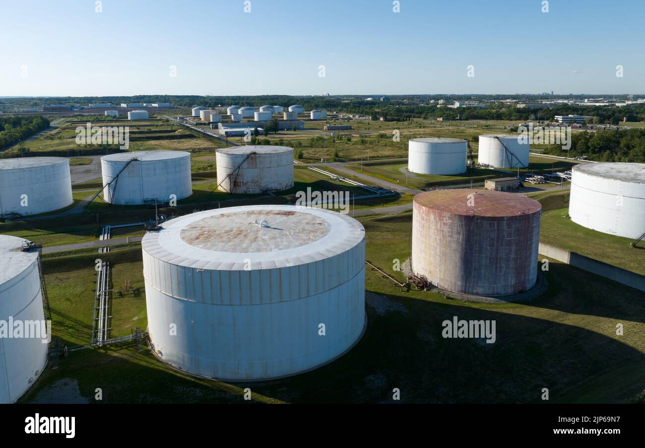 Una vista aérea mirando un gran campo de tanques de almacenamiento de petróleo crudo, visto un día soleado. Foto de stock