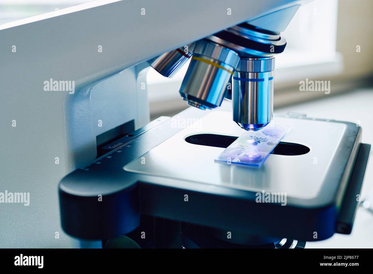 Investigación de la muestra de prueba bajo microscopio médico en laboratorio, primer plano Foto de stock