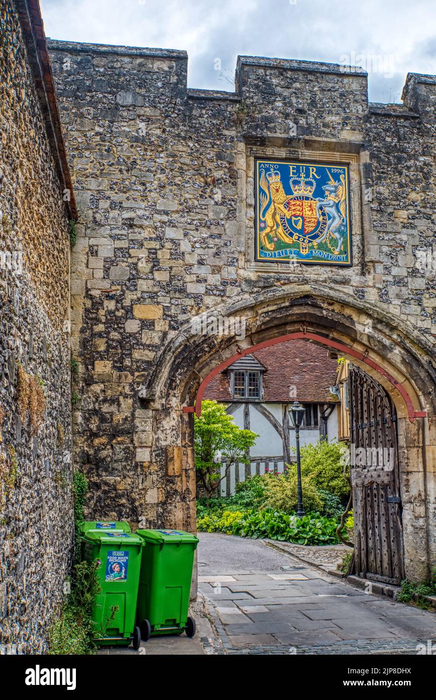 Muro de la ciudad y contenedores de ruedas verdes. Antigua puerta de la ciudad, cerca de Kings Gate, Winchester, Reino Unido Foto de stock