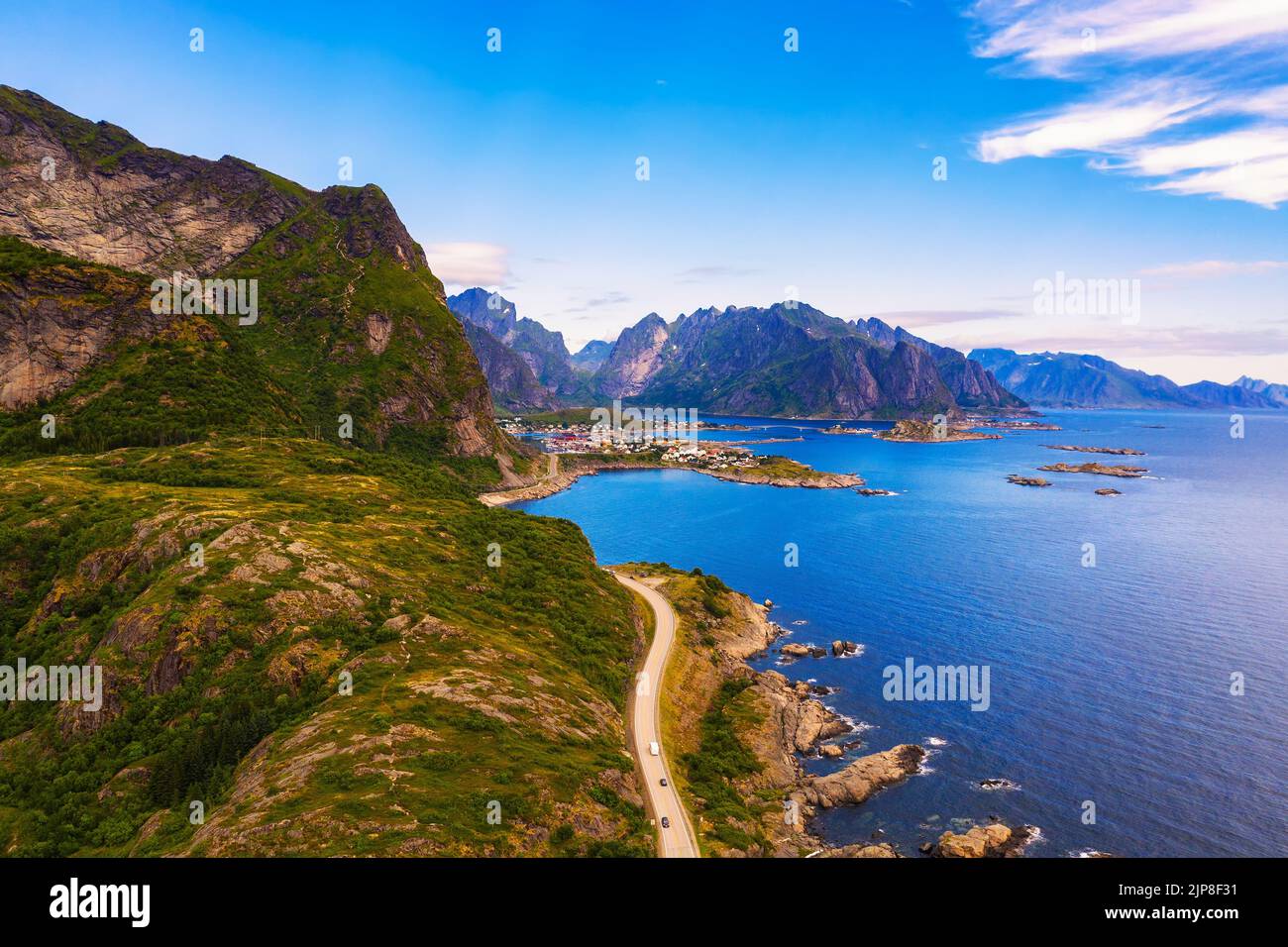 Camino a la aldea de Reine rodeado de altas montañas y el mar en las islas Lofoten Foto de stock