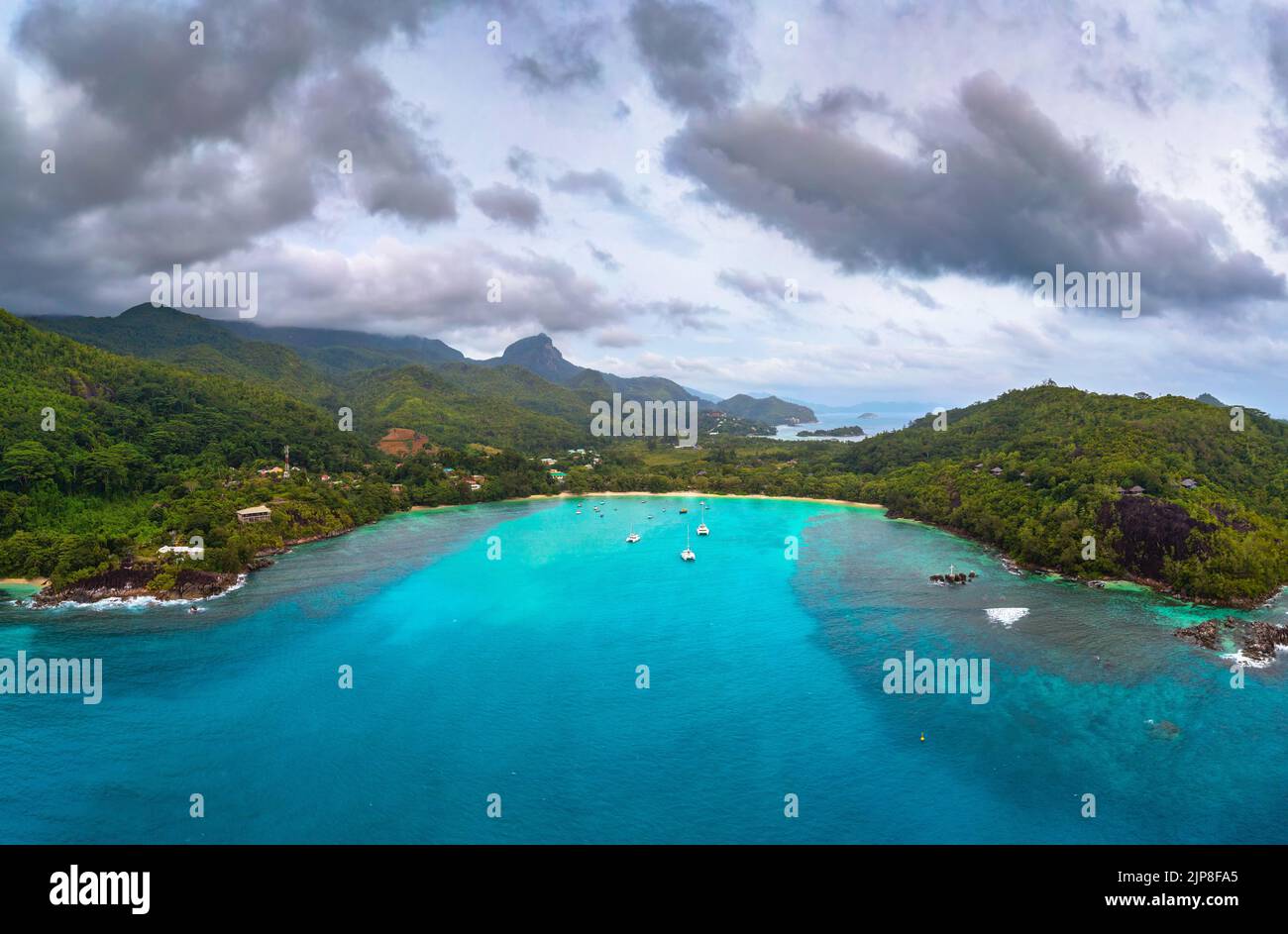Vista aérea de la isla Mahe con yates, montañas y el Océano Índico en Seychelles Foto de stock