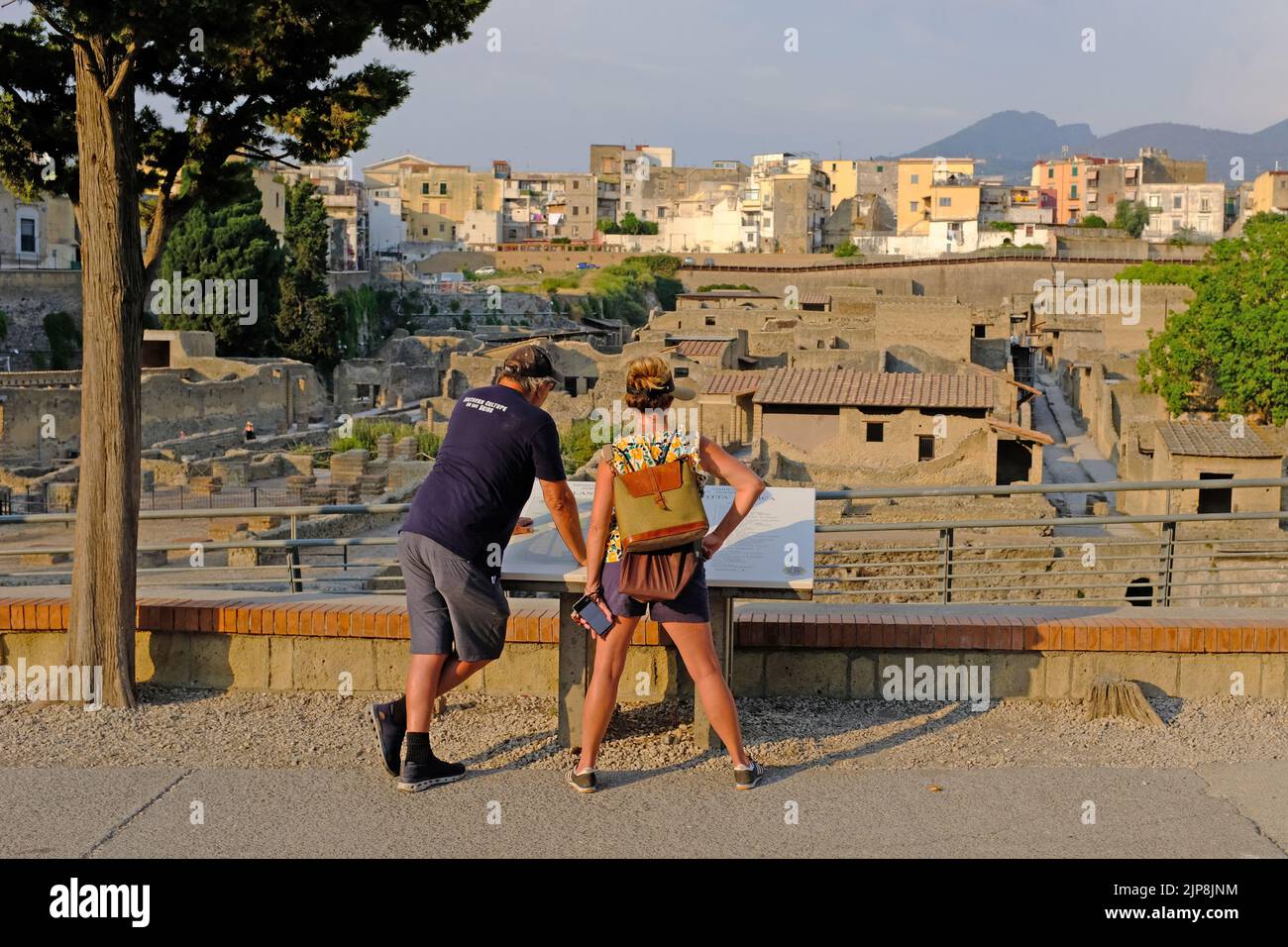 Dos turistas en Herculano leyendo un mapa del sitio Foto de stock