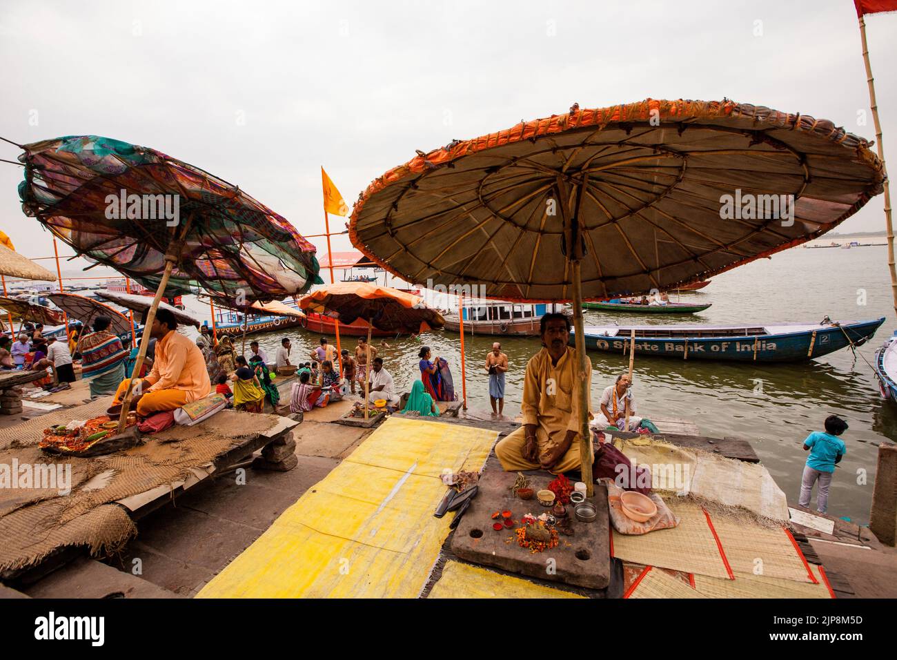 Sacerdote sentado bajo un paraguas enorme en Dashashwamedh Ghat en el río Ganga Ganges, Varanasi, Banaras, Benaras, Kashi, Uttar Pradesh, India Foto de stock