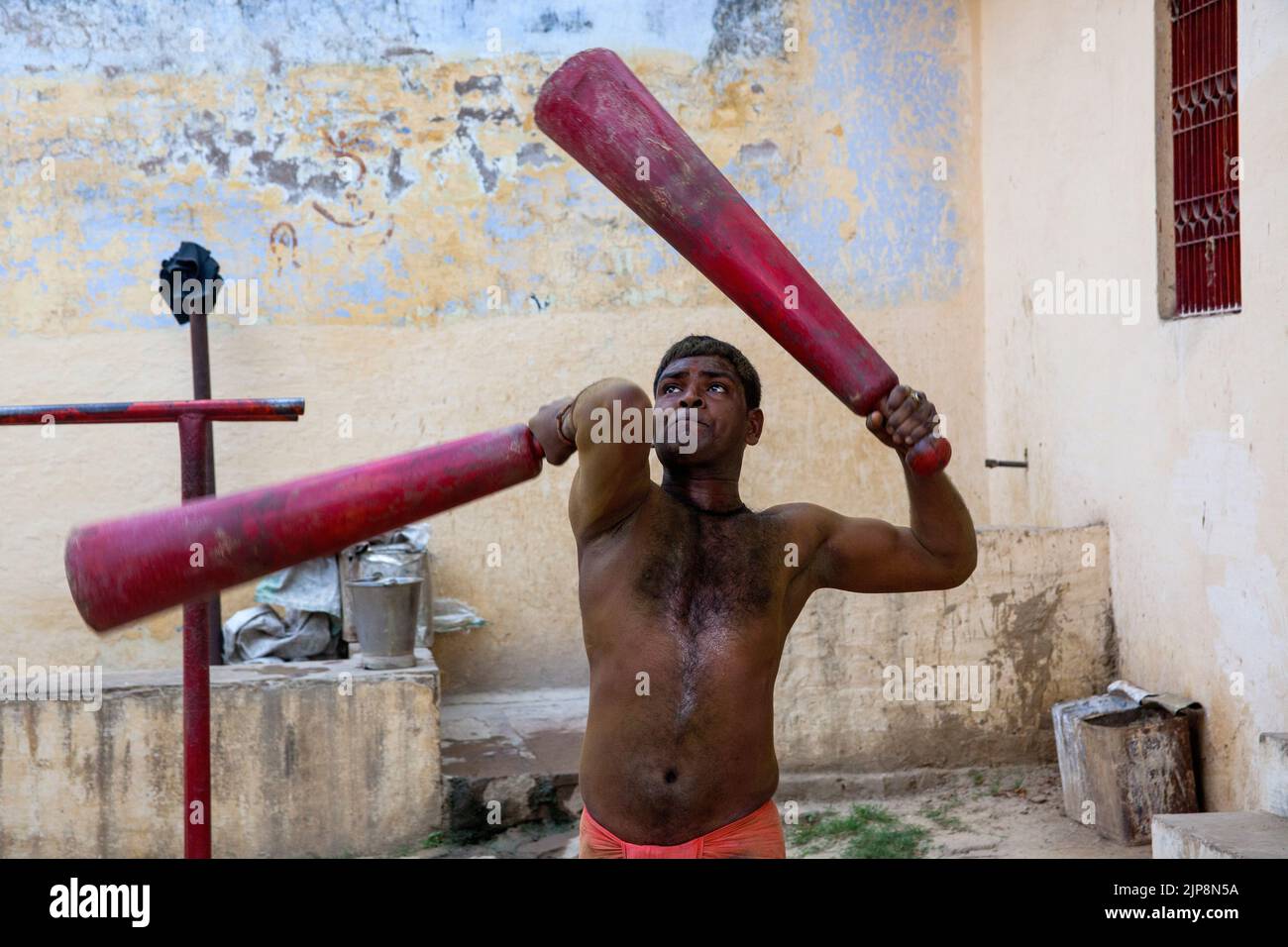 Luchador indio ejercitando con los clubs indios de madera mugdar, Tulsi Ghat, Varanasi, Banaras, Benaras, Kashi, Uttar Pradesh, India Foto de stock
