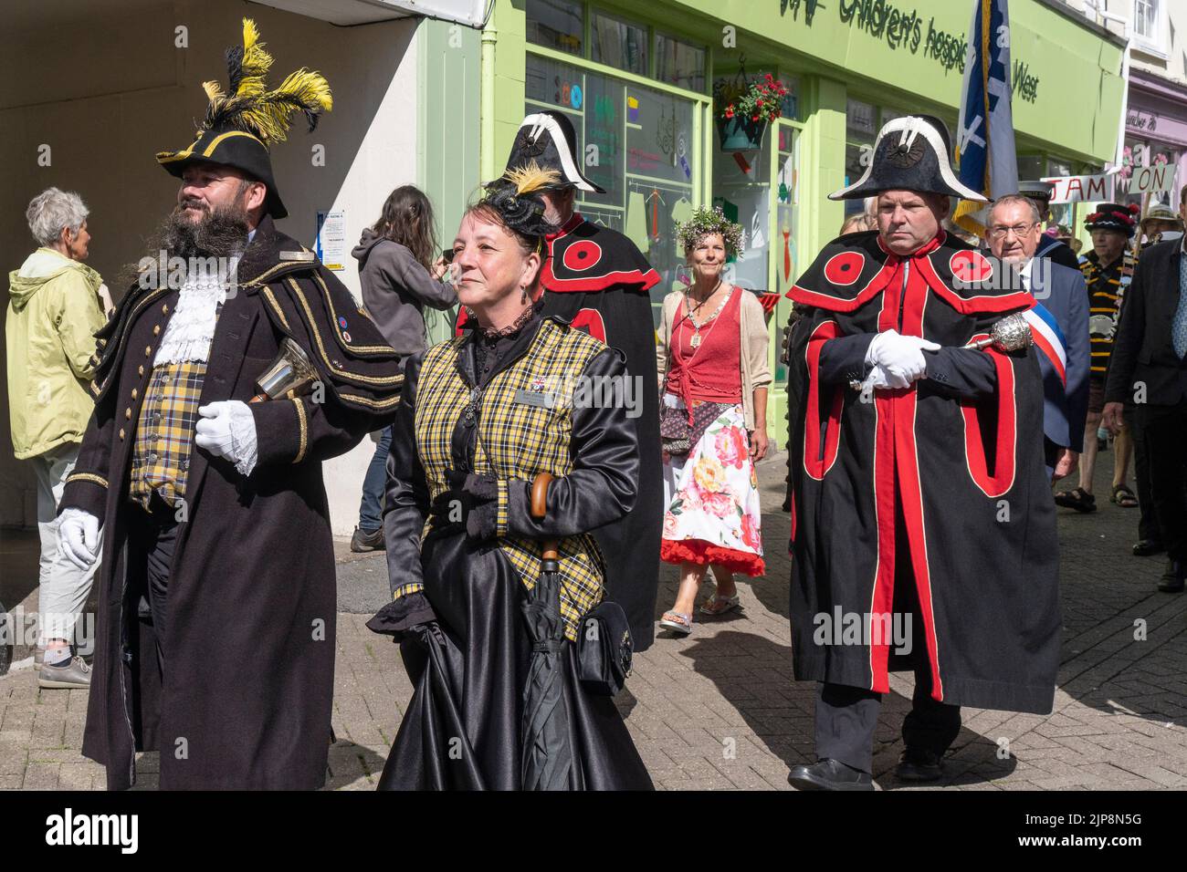 Philip Northcott Town Crier acompañado por su esposa Rose Northcott dirigiendo el Civic Parade durante el Mazey Day Golowan Festival en Penzance en Cornwall Foto de stock