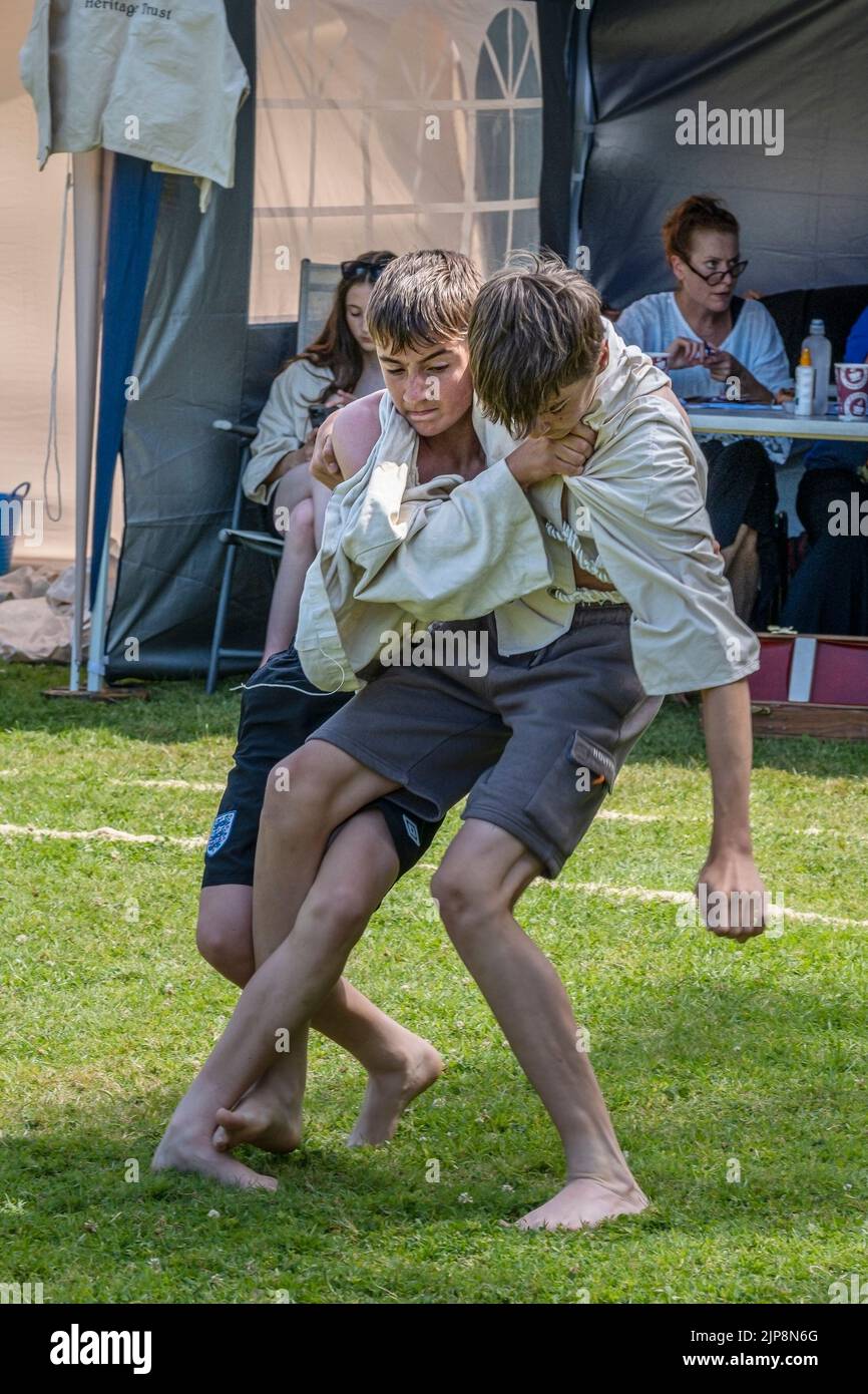 Dos jóvenes hermanos adolescentes compitiendo en el Grand Cornish Wrestling Tournament en el pintoresco pueblo verde de St Mawgan en Pydar en Cornwall in Foto de stock