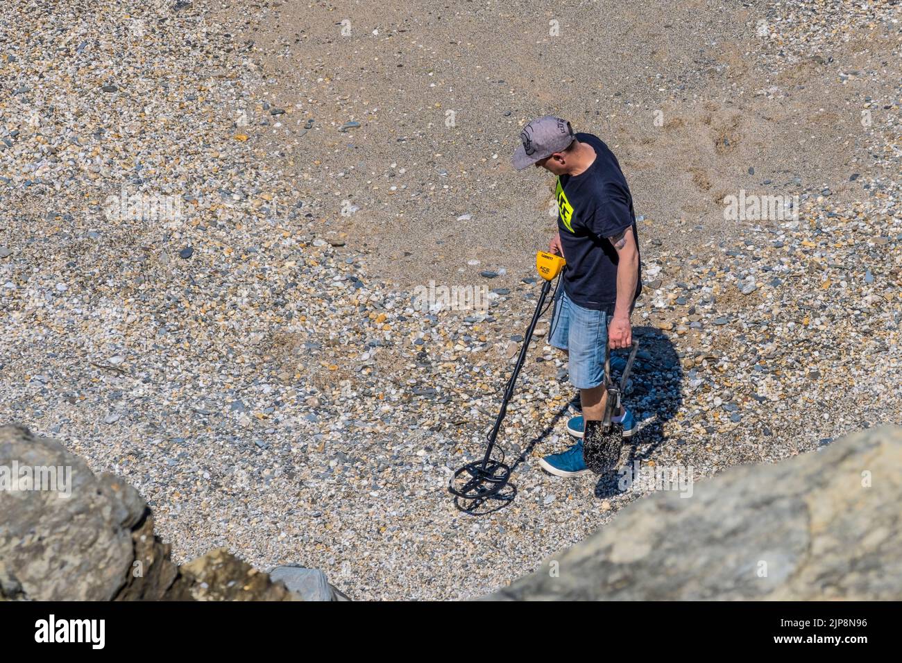 Un hombre; detective de metal buscando en una playa en Cornwall en el Reino Unido. Foto de stock