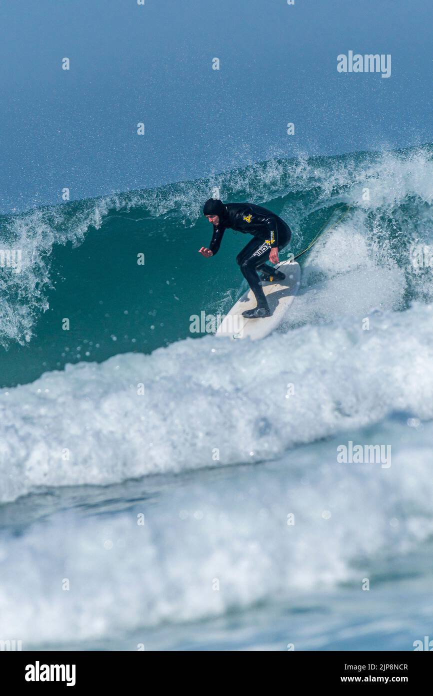 Espectacular acción surfear como surfista cabalga una ola en Fistral en Newquay en Cornwall en el Reino Unido. Foto de stock